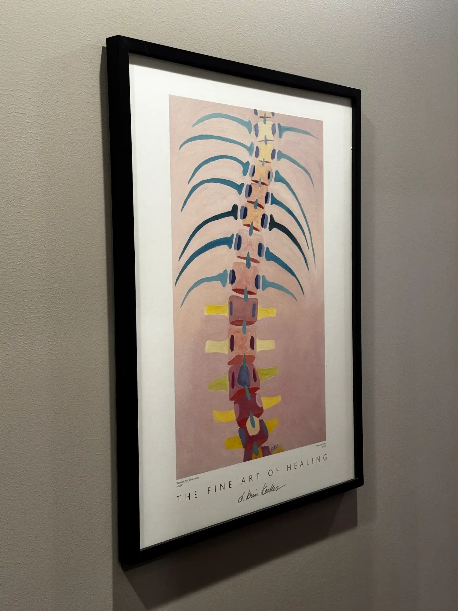 A framed abstract painting of a colorful human spine and ribs on a pink background, with text 'The Fine Art of Healing' and artist signature.